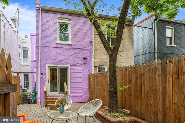 a backyard of a house with table and chairs