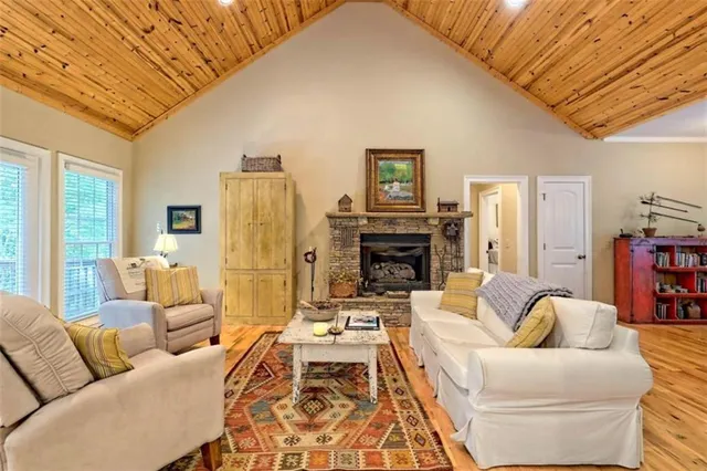 a living room with furniture a fireplace and a large window