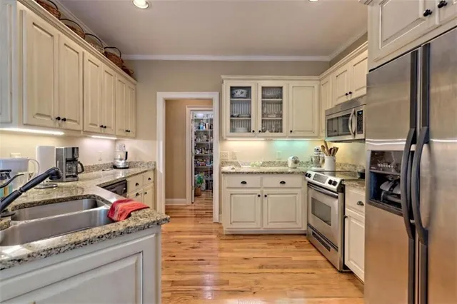 a kitchen with stainless steel appliances granite countertop a refrigerator stove and sink