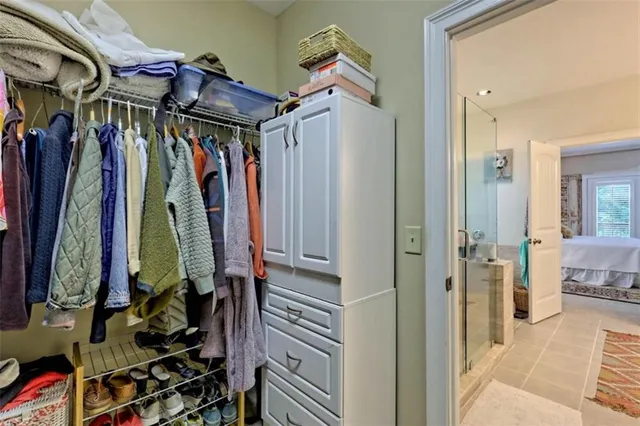 a view of walk in closet with clothes and shoes