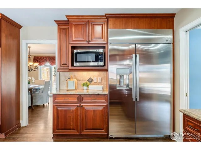 a kitchen with granite countertop a refrigerator a oven a sink and dishwasher