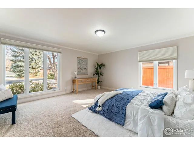 a bedroom with a bed and a large window