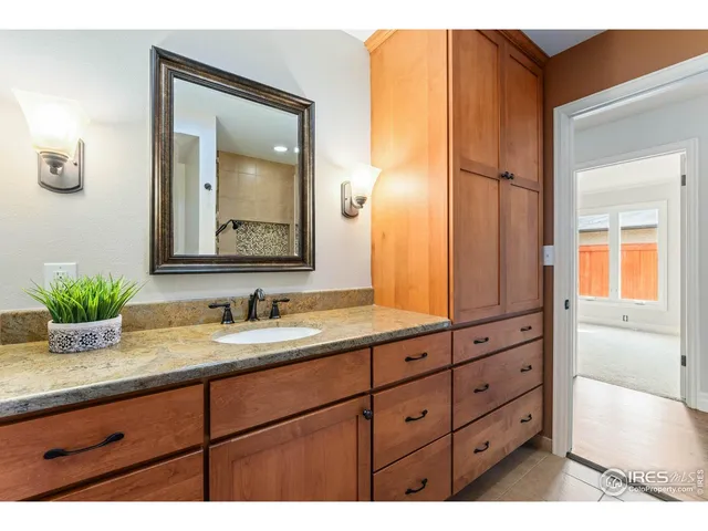 a bathroom with a granite countertop sink and a mirror