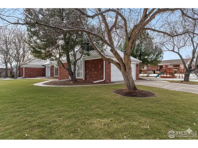 a front view of a house with garden and trees