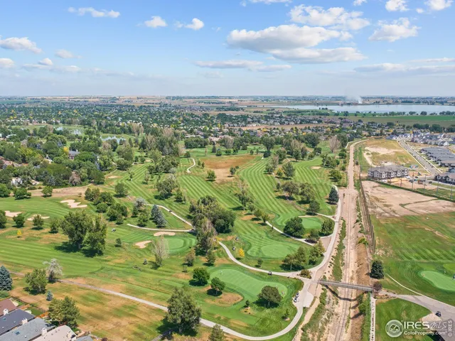an aerial view of residential houses with outdoor space and trees