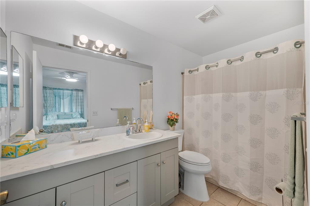 205 Winter Ridge Boulevard Winter Haven, FL 33881 - Photo 12 of 36 a bathroom with a granite countertop sink a toilet and a shower
