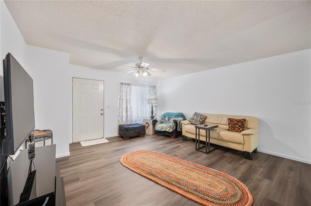 205 Winter Ridge Boulevard Winter Haven, FL 33881 - Photo 5 of 36 a living room with furniture and a chandelier