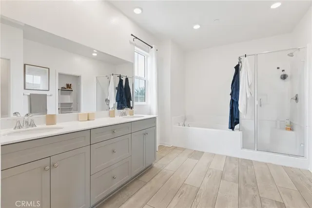 a bathroom with a double vanity sink a mirror and a bathtub