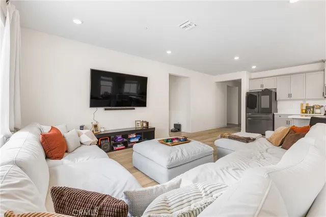 a bedroom with a bed a television and a refrigerator