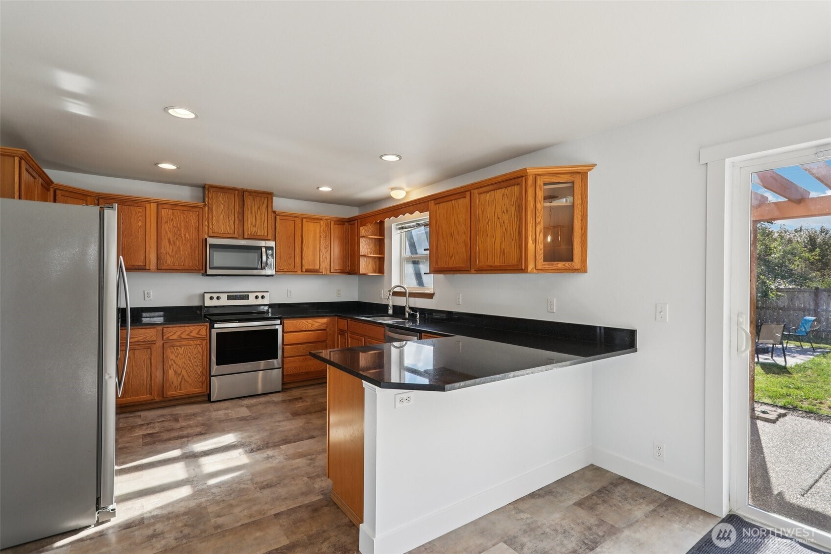114 Weaver Street Northeast Orting, WA 98360 - Photo 13 of 40 a kitchen with stainless steel appliances granite countertop a sink a stove and a refrigerator