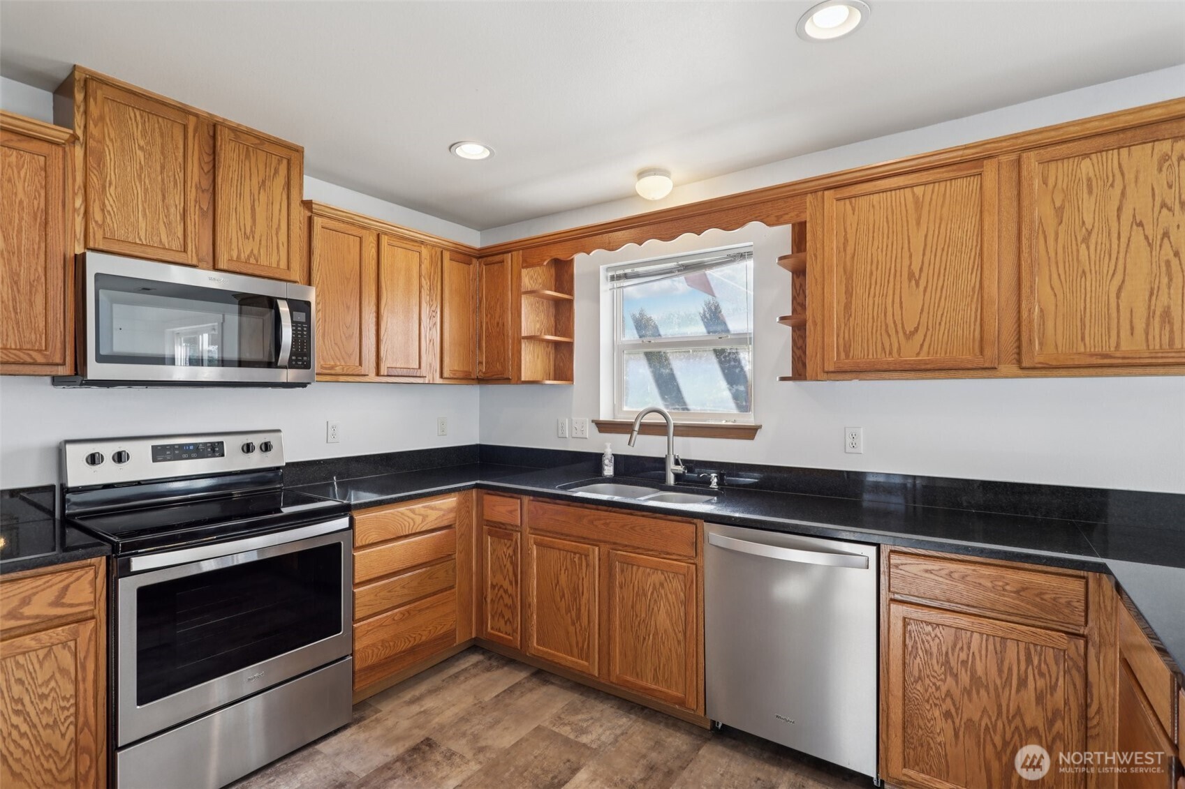 114 Weaver Street Northeast Orting, WA 98360 - Photo 17 of 40 a kitchen with granite countertop a sink stove and microwave