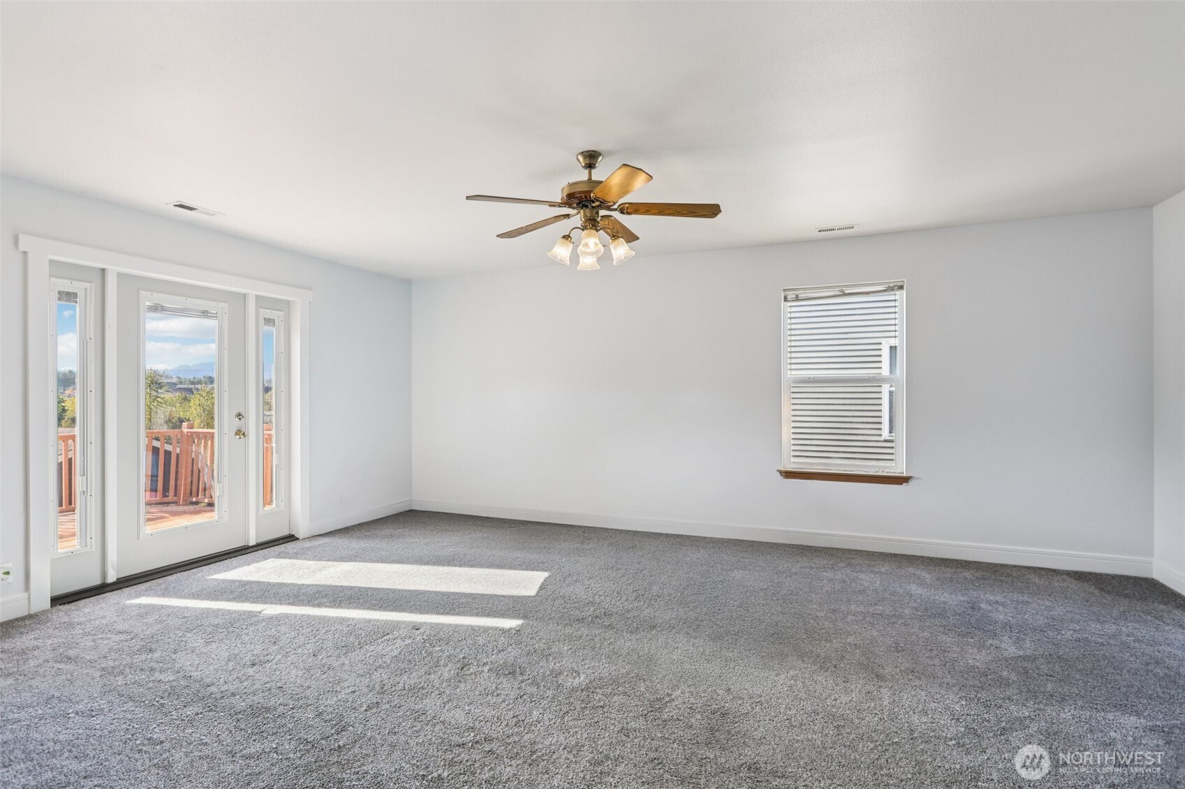 114 Weaver Street Northeast Orting, WA 98360 - Photo 21 of 40 an empty room with windows and chandelier fan