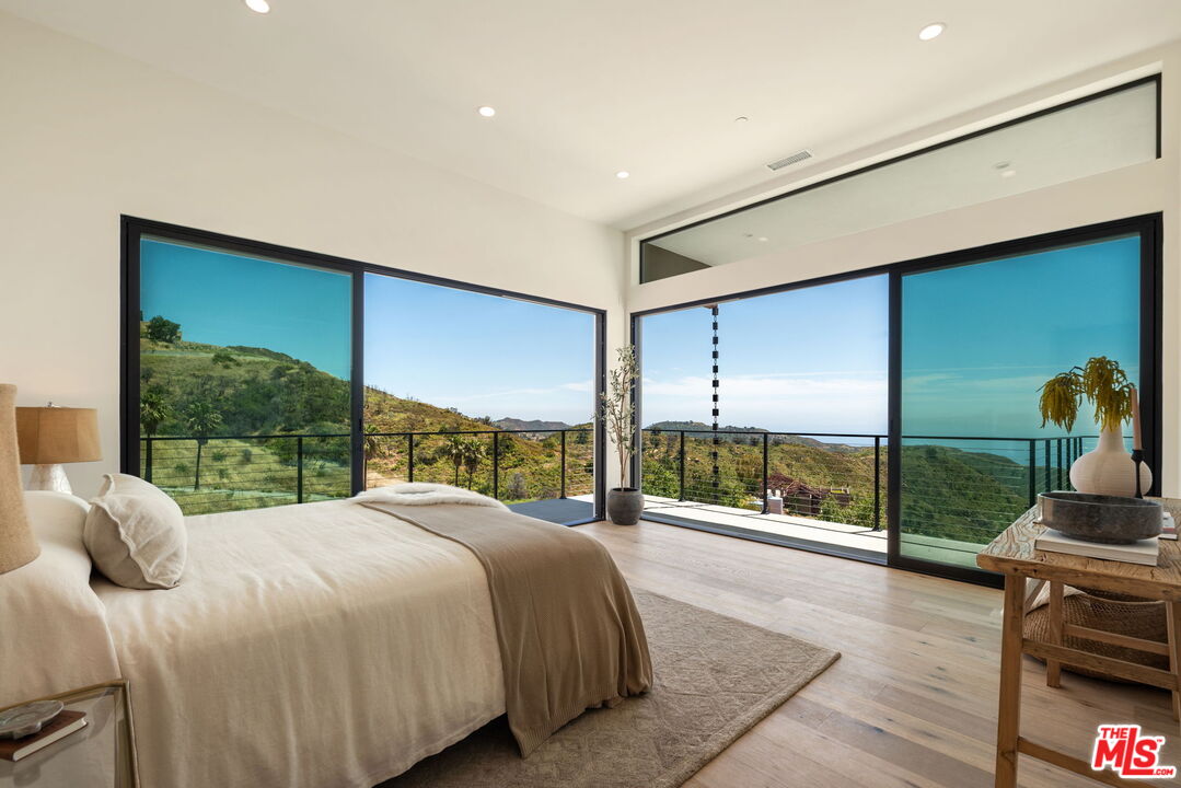 2165 Little Las Flores Road Topanga, CA 90290 - Photo 12 of 40 a large bedroom with a bed and large window