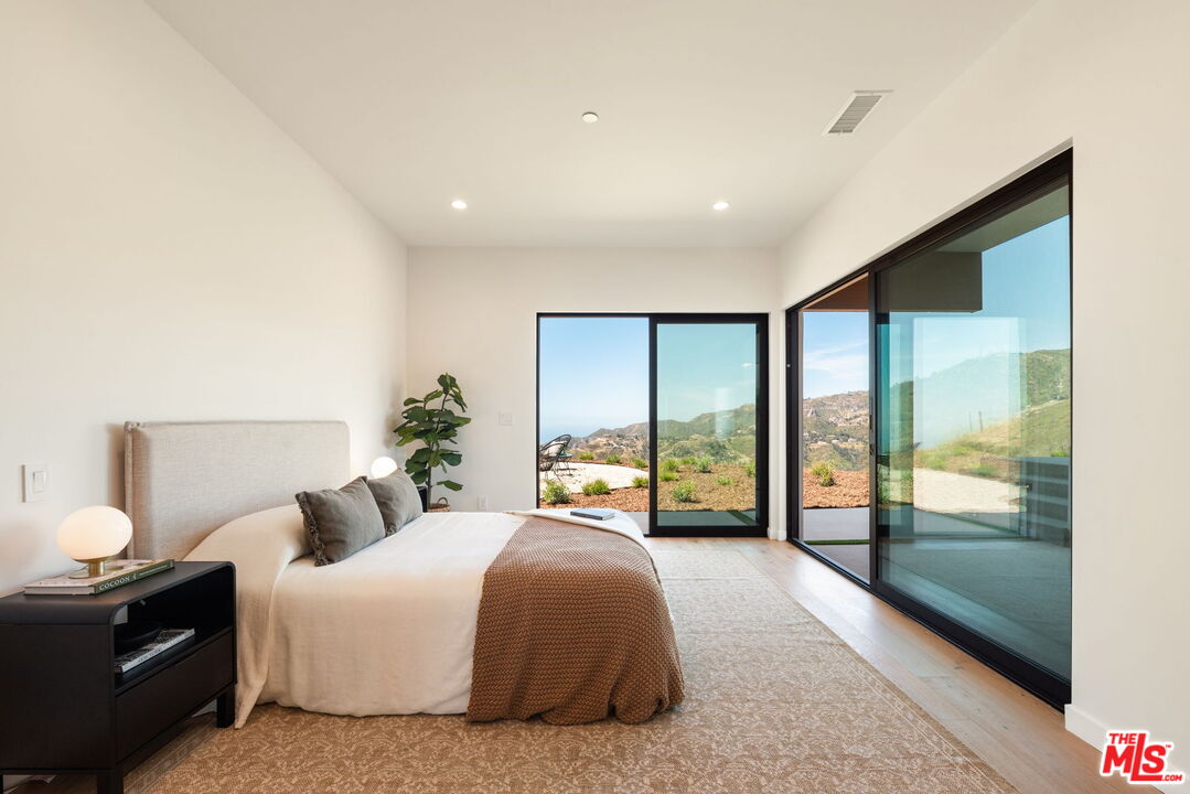 2165 Little Las Flores Road Topanga, CA 90290 - Photo 21 of 40 a bedroom with a large bed and a large window
