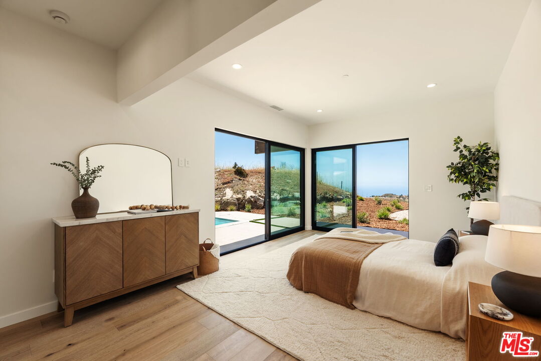 2165 Little Las Flores Road Topanga, CA 90290 - Photo 25 of 40 a large bedroom with bed and sliding glass door