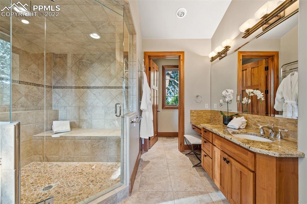 3833 Lorraine Road Larkspur, CO 80118 - Photo 12 of 40 a bathroom with a granite countertop sink a mirror and a bathtub