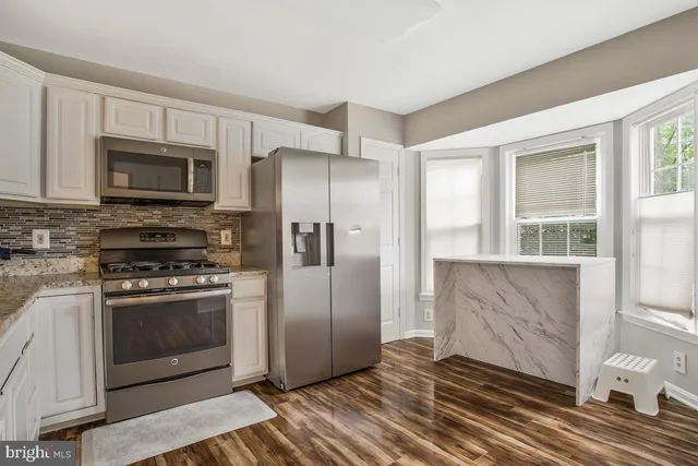 a kitchen with granite countertop a refrigerator and a stove