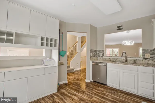 a kitchen with kitchen island granite countertop a sink and cabinets