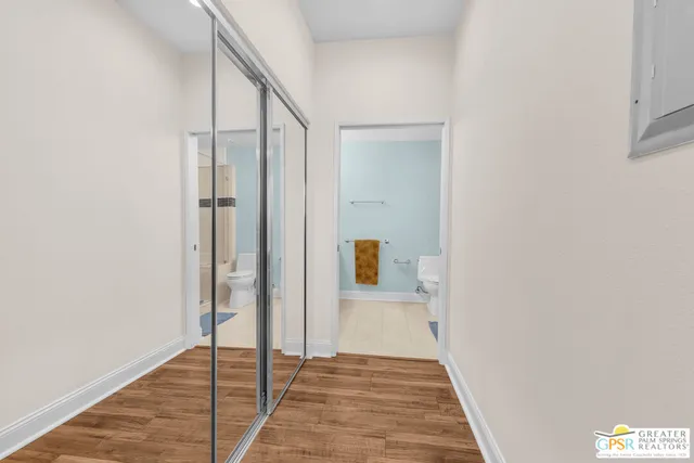 a view of a hallway with wooden floor and staircase