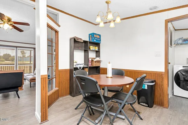 a kitchen with stainless steel appliances granite countertop a refrigerator a sink dishwasher a dining table and chairs with wooden floor