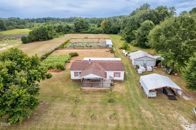 an aerial view of a house with a yard and parking space