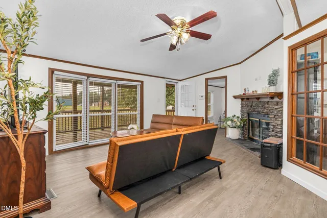 a living room with furniture a flat screen tv and floor to ceiling window