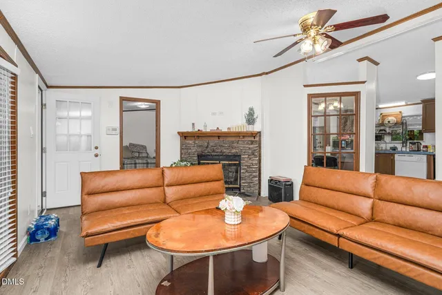 a living room with furniture a flat screen tv and a large window