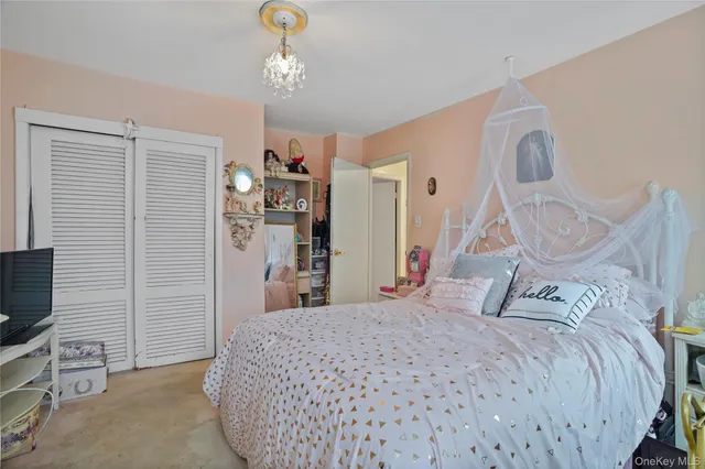 a bedroom with a bed and a flat tv screen on the dresser