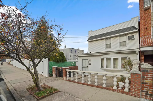 a front view of a house with a tree