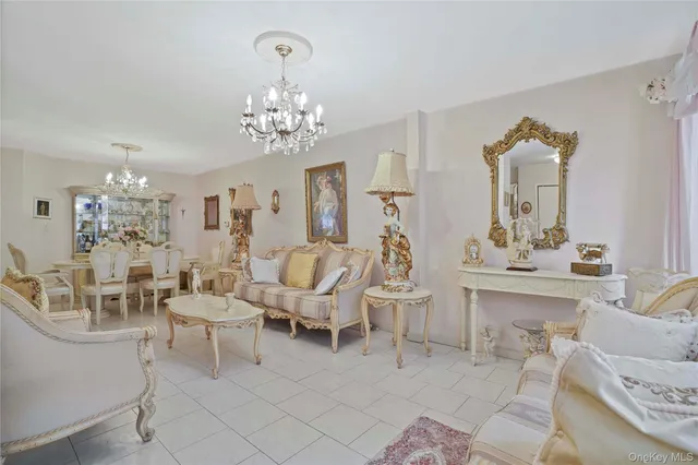 a living room with furniture chandelier and a view of kitchen