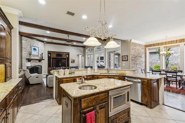 a view of a kitchen with granite countertop a stove a sink a dining table and chairs