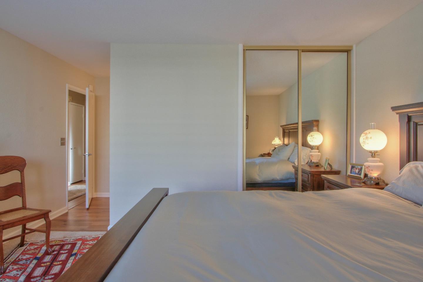 4000 Rio Road, Unit 26 Carmel, CA 93923 - Photo 14 of 27 a bedroom with a bed and a lamp on dresser