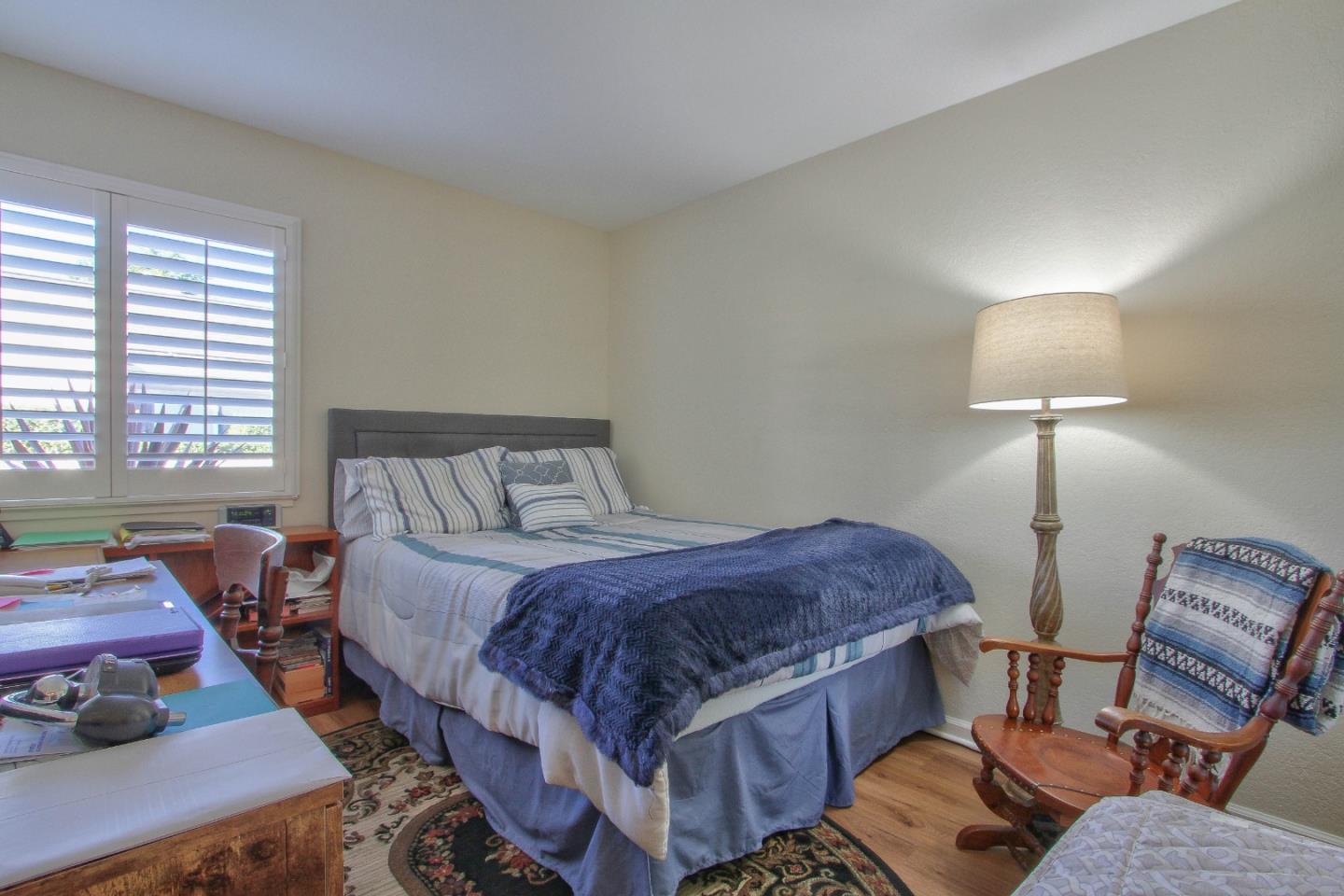 4000 Rio Road, Unit 26 Carmel, CA 93923 - Photo 17 of 27 a spacious bedroom with a bed and a lamp