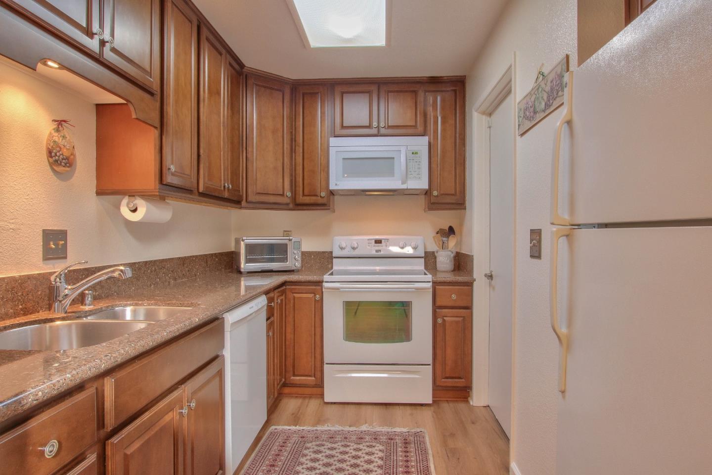 4000 Rio Road, Unit 26 Carmel, CA 93923 - Photo 9 of 27 a kitchen with a sink stove and refrigerator