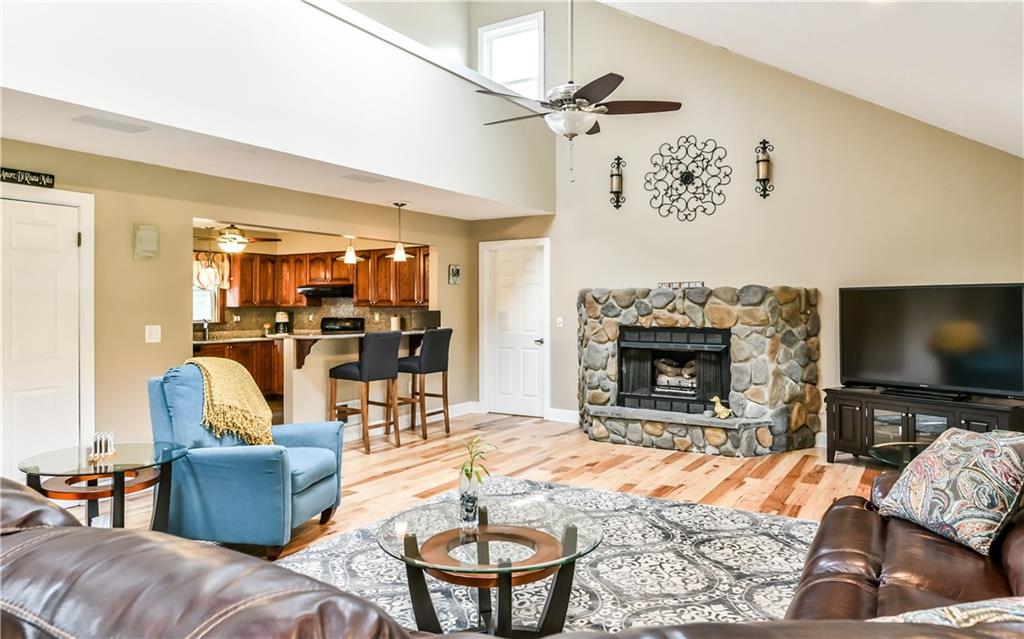 1064 Freedom Crider Road Freedom, PA 15042 - Photo 7 of 25 Great Room open to kitchen showing River Rock fireplace and gorgeous Hickory Hard Woods.
