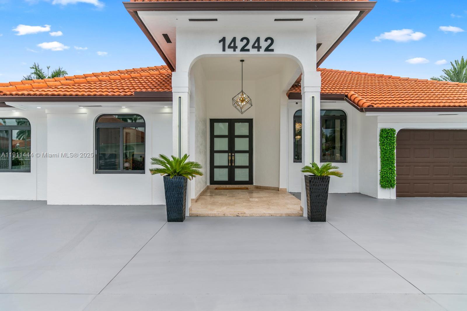 a front view of a house with potted plants