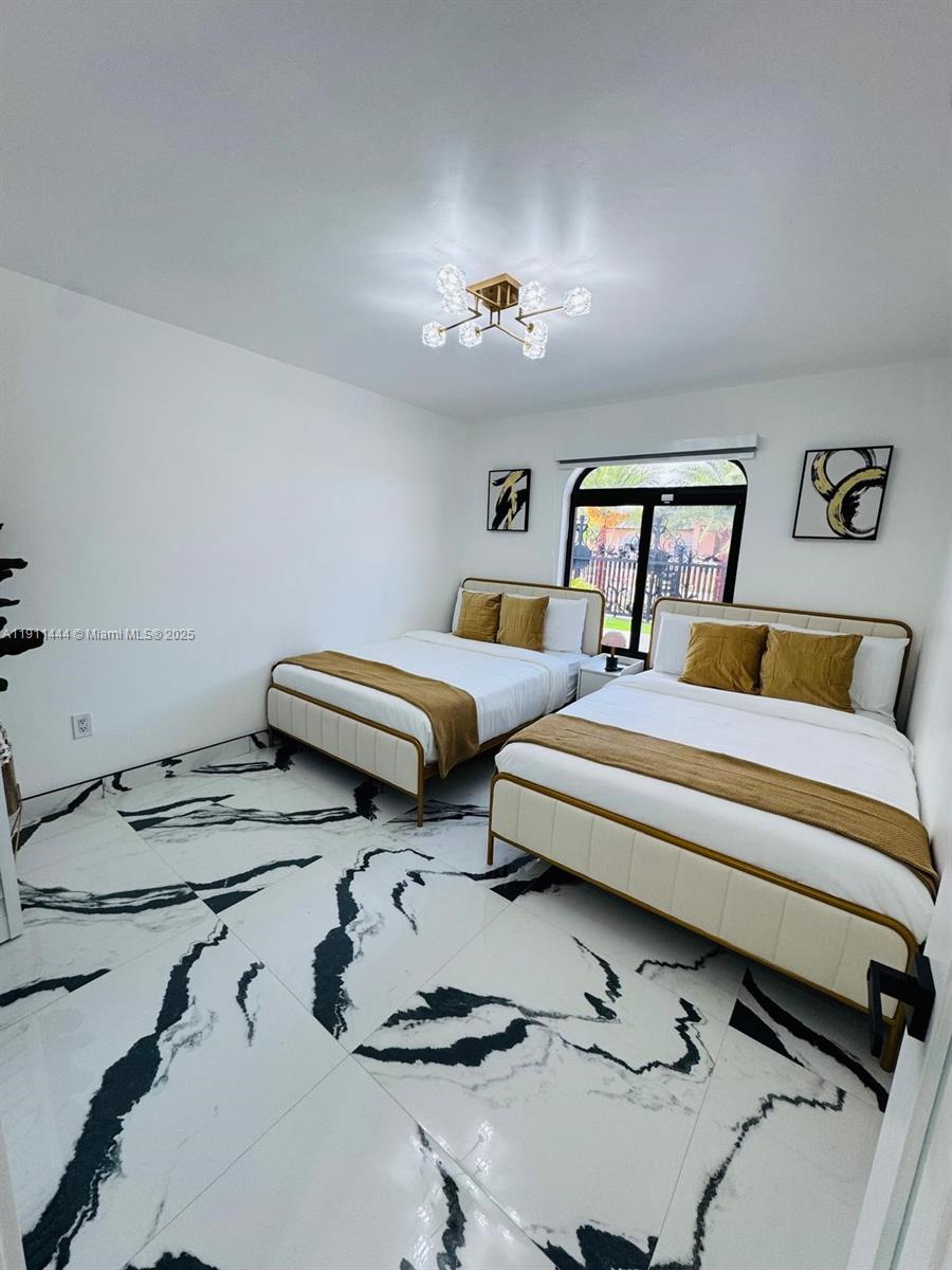 14242 Southwest 30th Street Miami, FL 33175 - Photo 32 of 45 a bedroom with two beds and a chandelier