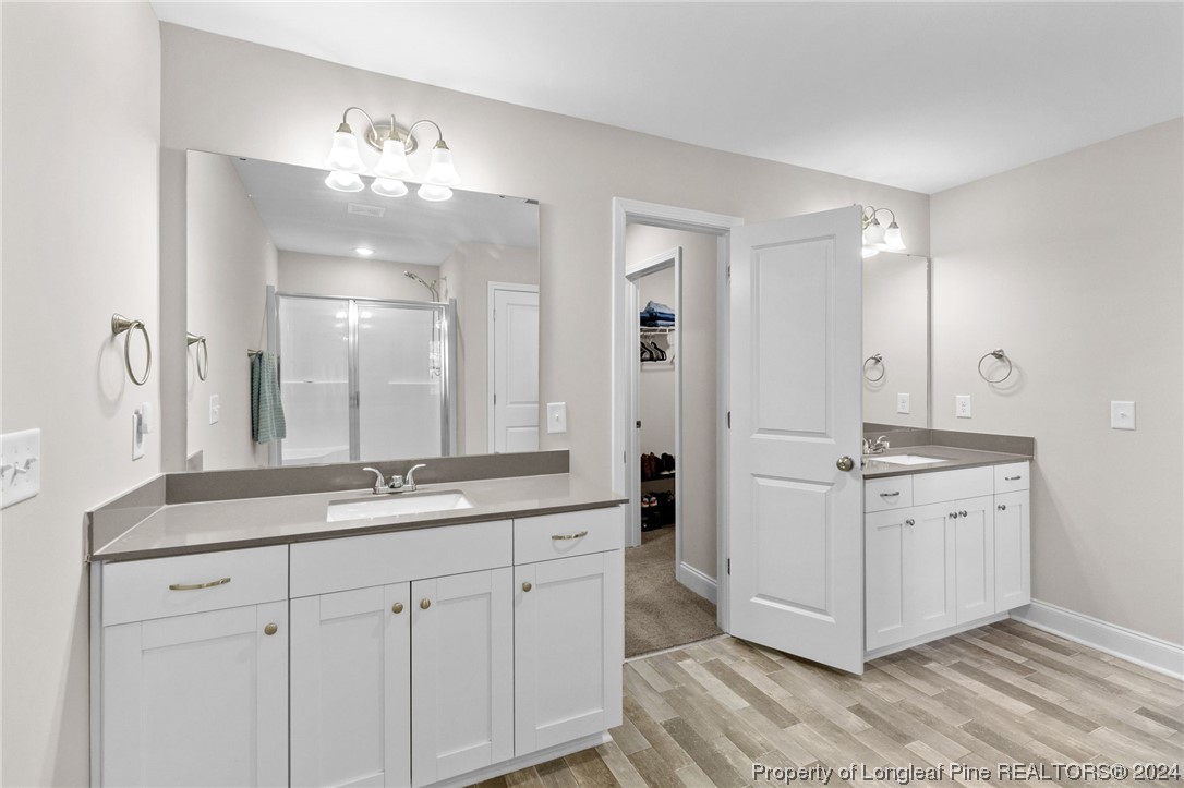 740 Walker Road Bunnlevel, NC 28323 - Photo 23 of 27 a spacious bathroom with a granite countertop sink a mirror and a shower