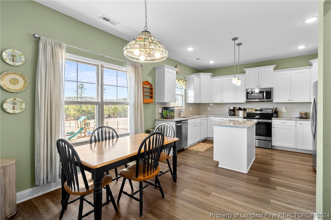 740 Walker Road Bunnlevel, NC 28323 - Photo 9 of 27 a view of a dining room with furniture large window and wooden floor