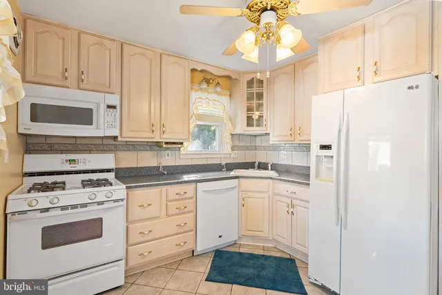 a kitchen with granite countertop white cabinets and white appliances