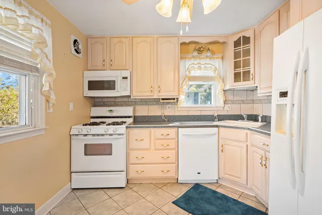 a kitchen with granite countertop a refrigerator and a sink