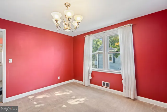 a view of a livingroom with a chandelier fan and windows