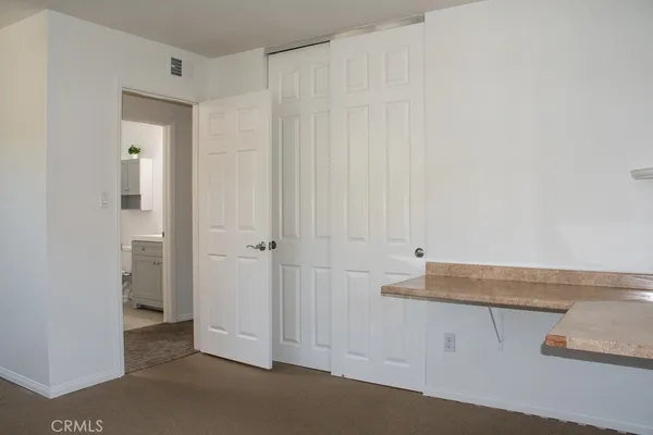 a view of a refrigerator in kitchen and an empty room