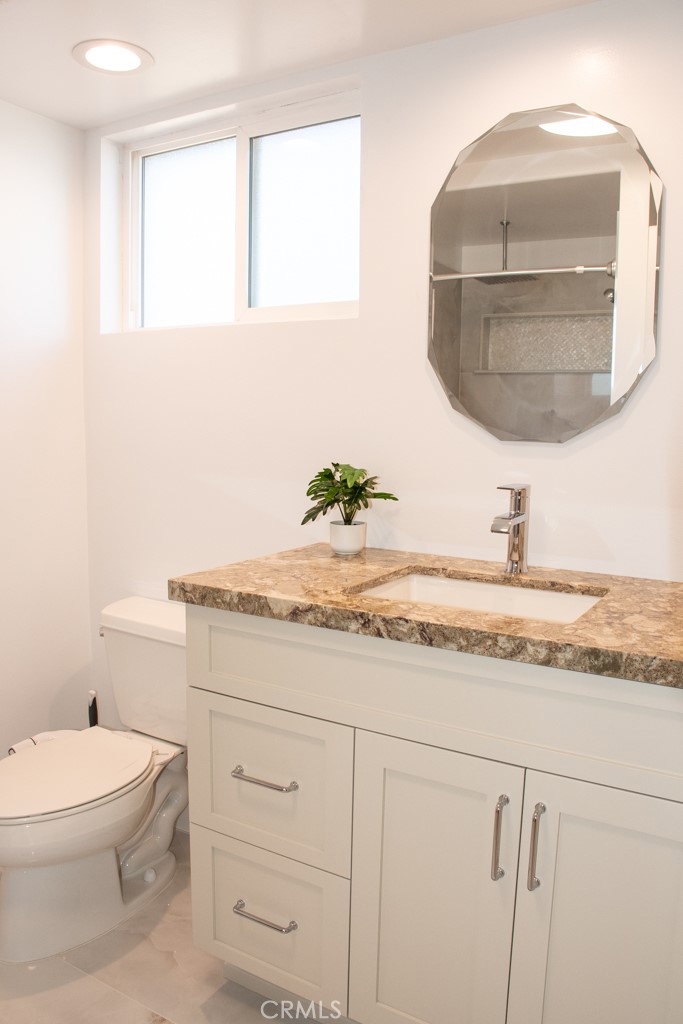 933 Eastside Road El Cajon, CA 92020 - Photo 53 of 70 a bathroom with a granite countertop toilet sink and mirror
