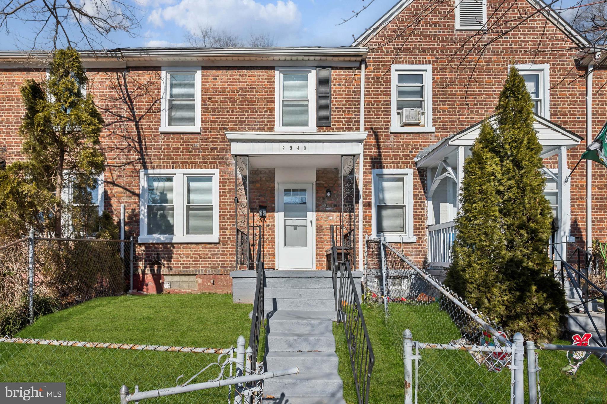 front view of house with a yard and potted plants