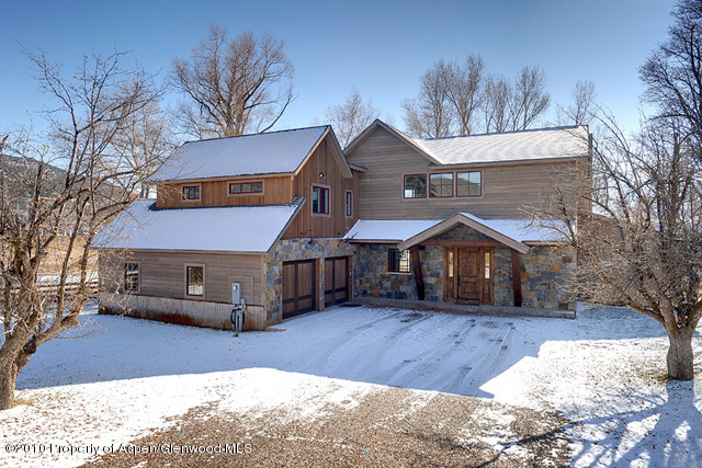 a front view of a house with a yard covered in snow