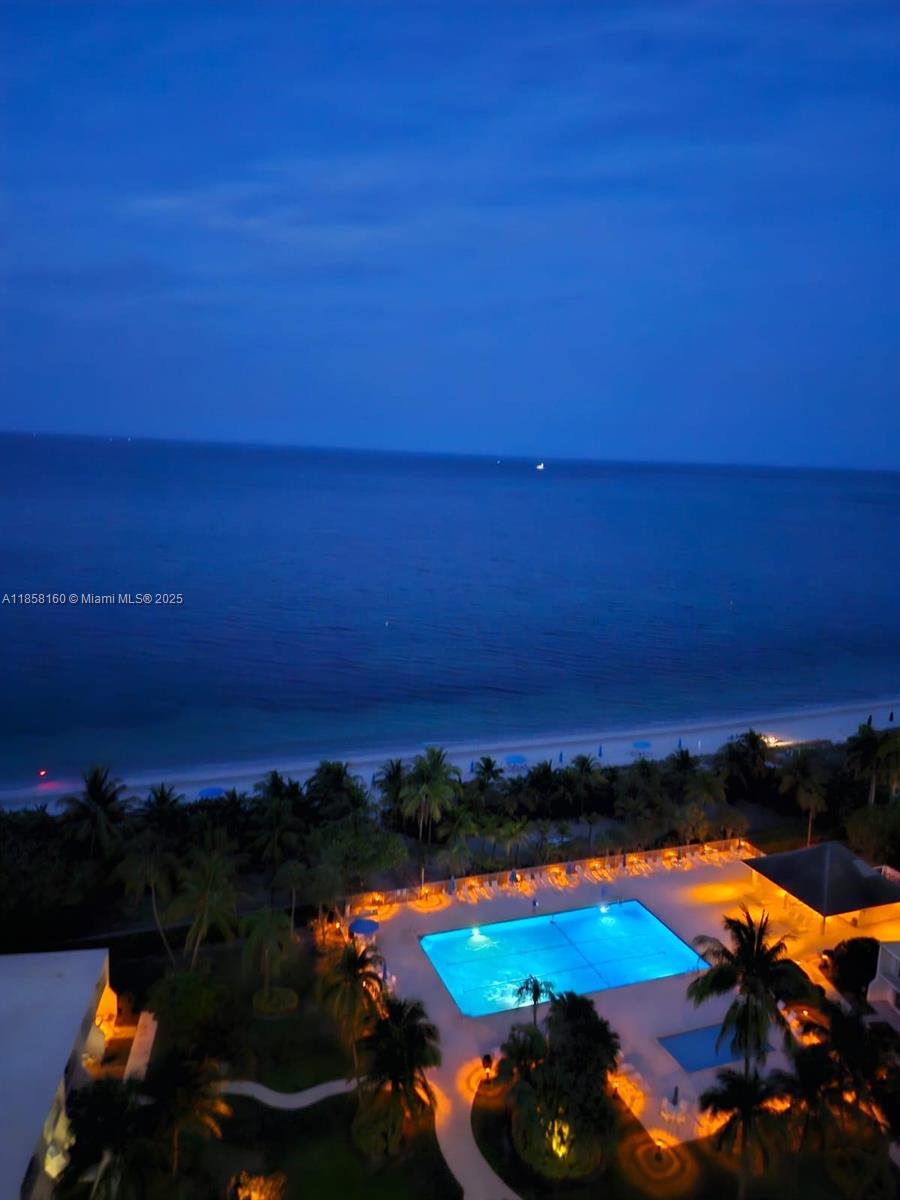 an aerial view of residential houses with outdoor space and ocean view