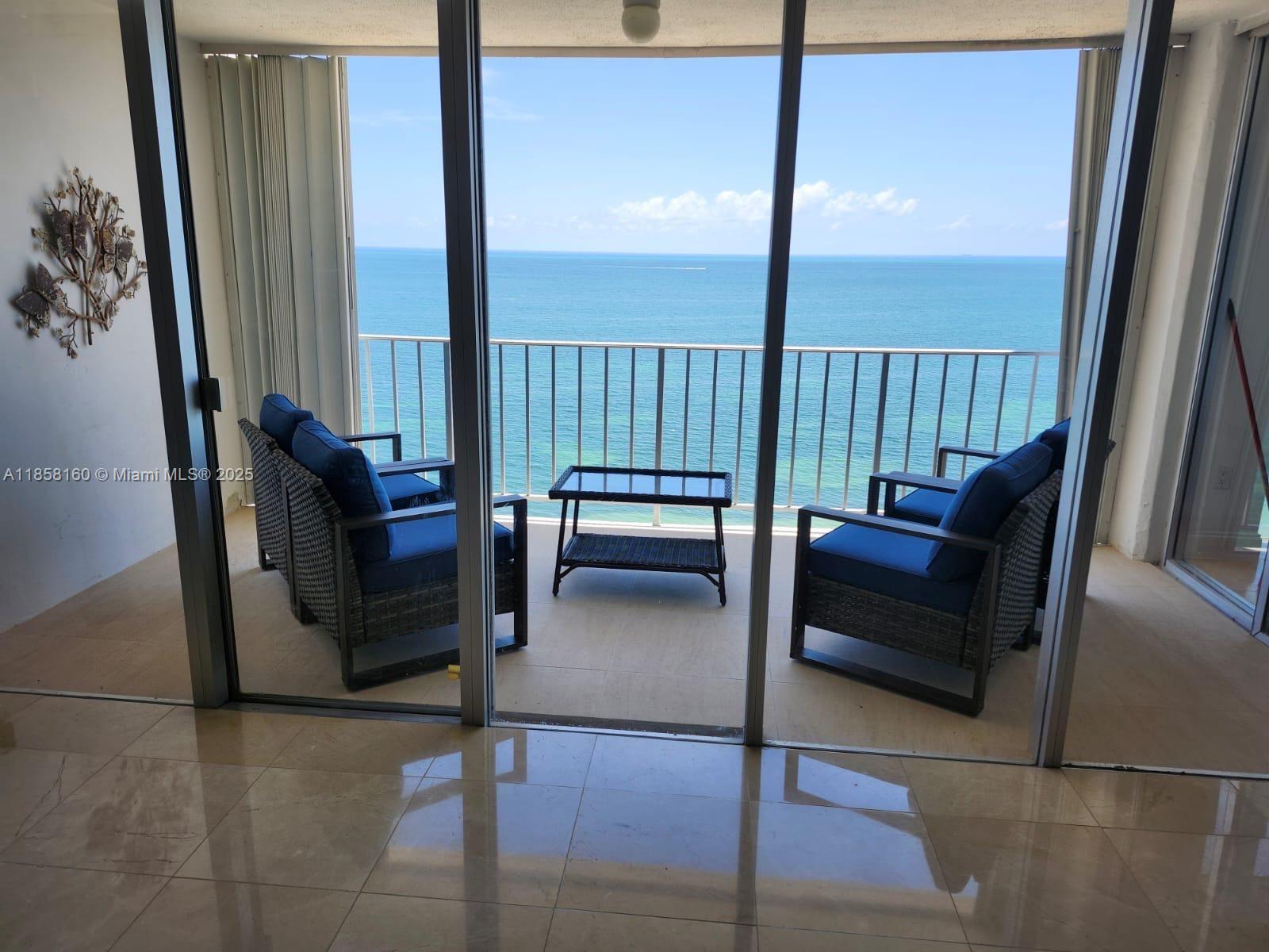 881 Ocean Drive, Unit 16F Key Biscayne, FL 33149 - Photo 2 of 6 a living room with furniture and a floor to ceiling window