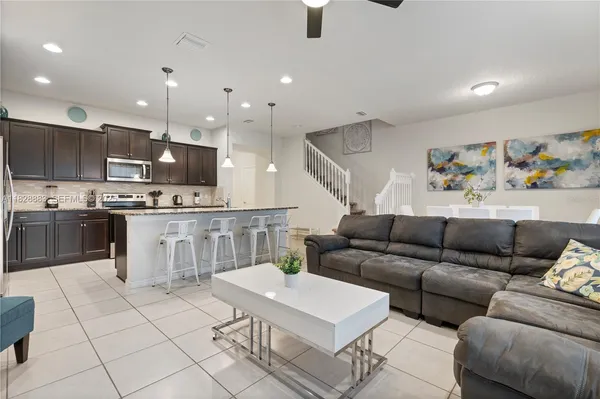 a living room with furniture and kitchen view