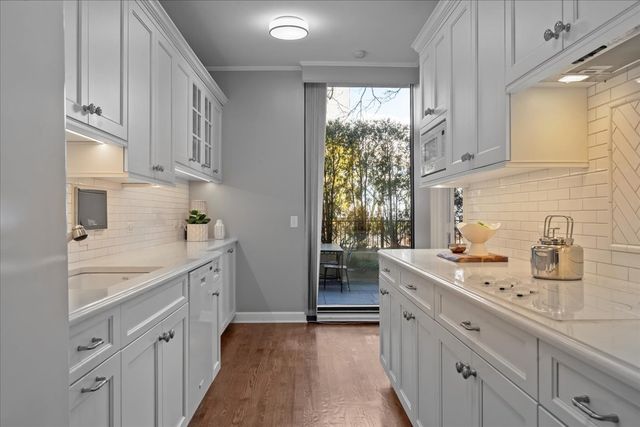 a large white kitchen with stainless steel appliances sink a stove and cabinets